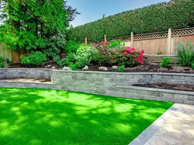 A lively outdoor area is created by lovely garden beds with brilliant flowers and a well-kept green lawn.