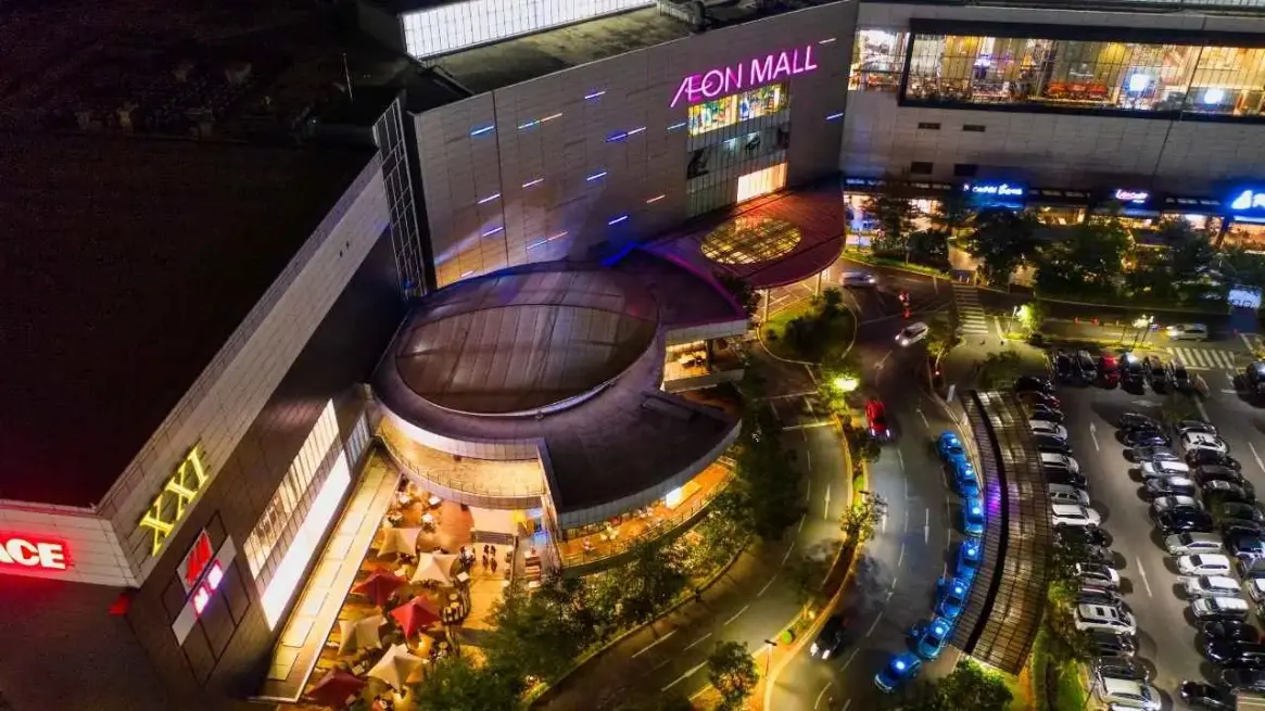 Shopping mall landscaping service maintaining trees, planters, and walkways around a busy retail center.